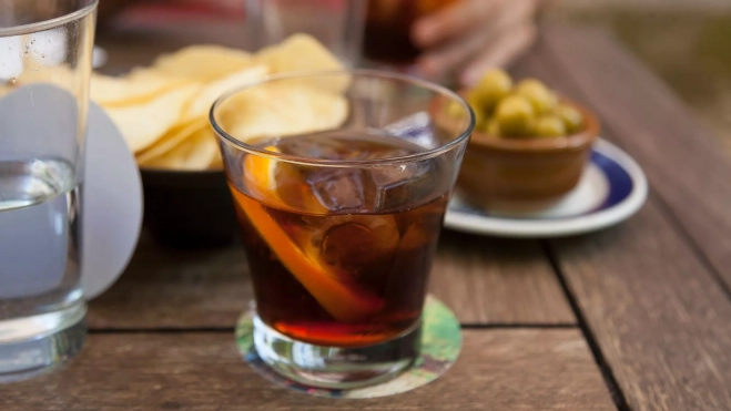 Vaso de vermut en una mesa con tapeo / Foto: Canva / Los 7 vermuts que querrás beber este verano: para amantes del aperitivo y del vermuteo