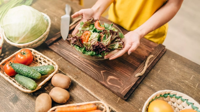 Persona preparando un plato con hortalizas / Foto: Canva