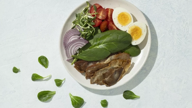 Plato con comida de dieta cetogénica y hojas de espinacas / FREEPIK